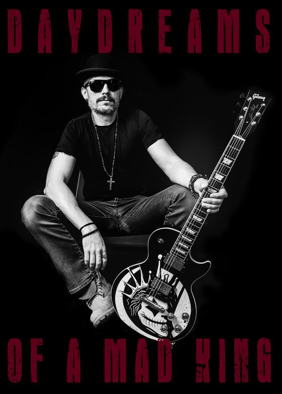 Guitariste assis tenant une Gibson Les Paul au logo DMK